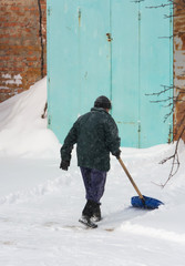 Man cleaning road from snow using shovel