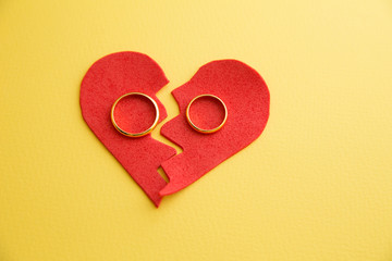 Wedding rings on the figure of a broken heart from a tree, hammer of a judge on a wooden...