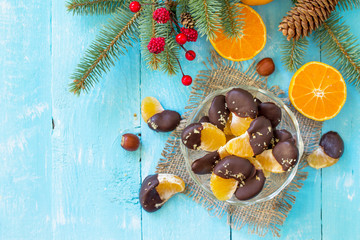 Slices of Tangerines in Chocolate. Dessert Tangerines on a wooden table. Top view flat lay background. Copy space.