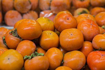 Pile of persimmon fruits background.