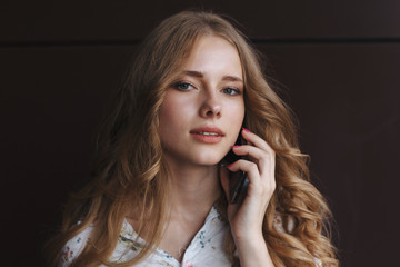 Young charming woman calling with cell phone,, attractive woman with cute smile talking with mobile phone while relaxing.closeup. business woman with