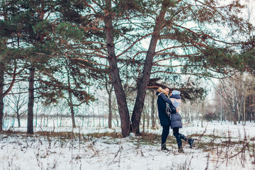 Fototapeta na wymiar Beautiful loving couple walking in winter forest together. People hugging outdoors