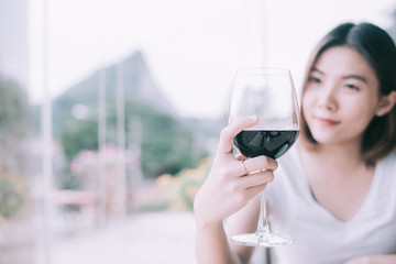 Outdoors portrait of a beautiful wine tasting tourist woman.Young Woman drinking wine in  Italian style restaurant with tone color.