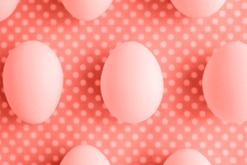 Eggs on dotted fabric background toned Living Coral color of the 2019 year.