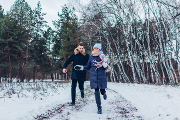 Fototapeta na wymiar Beautiful loving couple running in winter forest together. People having fun outdoors