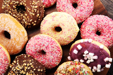 assorted donuts with chocolate frosted, pink glazed and sprinkles donuts