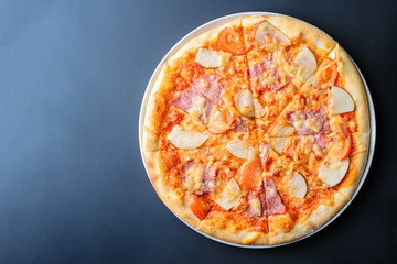 Italian pizza on a dark background with copy space, top view