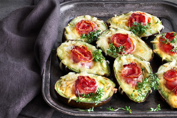 Keto diet dish: Avocado Boats with crunchy bacon, melted cheese and cress sprouts on dark