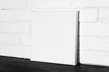 Canvas frame template, white brick wall on background. Side view.