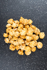 Handfuls of caramel popped popcorn kernels