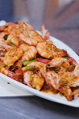 Grilled prawns or shrimps on plate on dark table