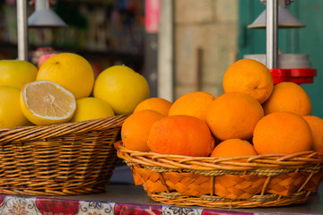 Pile of oranges and grapefruit on wicker baskets background