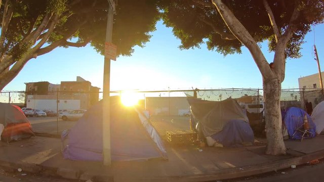 Moving shot of sidewalk homeless tent camps in the gritty skid row area of downtown Los Angeles.