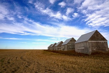 Prairie sky over row of barns