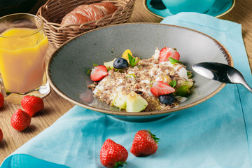 Bowl of oatmeal porridge with berry, close up
