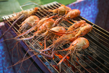 shrimp grilled bbq seafood on charcoal stove for sale at Thai street food market