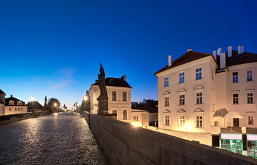 Prague at night, illuminated historical houses and Charles Bridge after rain