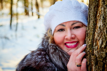 Portrait of beautiful plump woman in a nice winter forest