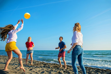 Group of young people playing volleyball on the beach