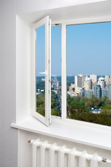 White window in empty room with heating and gray walls. Beautiful view from the window of the home. © Oleksandrum