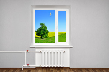 White window in empty room with heating and gray walls. Beautiful view from the window of the home.