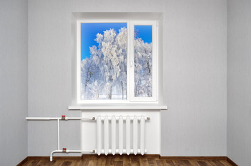 White window in empty room with heating and gray walls. Beautiful view from the window of the home.