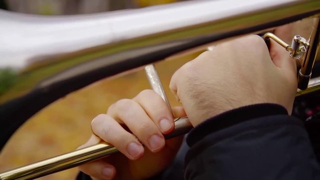 Close-up shot of a jazz musician's hands holding a wind intrument and playing a soul song.
