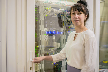 A woman is standing at the door to the server room. The girl is at the entrance to the data center.