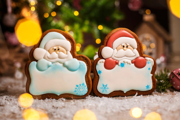 Holiday traditional food bakery. Two gingerbread of santa claus with copy space in cozy warm decoration with garland lights