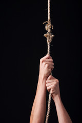 A person hanging from a frayed rope