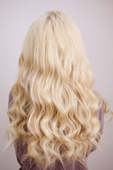 Back view of blonde with long luxurious curls.