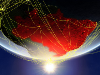 Brazil on model of planet Earth in sunrise with network representing travel and communication.