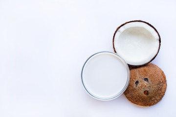 Obraz na płótnie Canvas Half Coconut with glass bowl of coconut milk