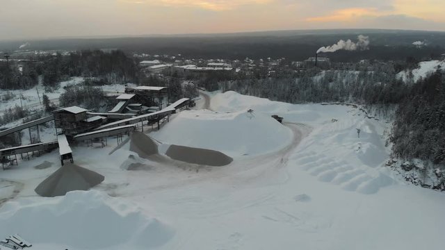 Mountain quarry on which trucks drive on the background of the Northern landscape. Aerial view. 4K