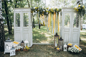 Wedding ceremony. Festive arch. Beautiful wedding decor with many flowers, lemons, balloons and candles. Celebration, top view