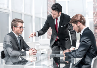 annoyed businessman holds a meeting with employees