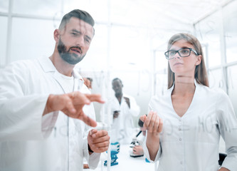 chemists stand by a transparent wall with written formulas