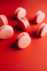 Composition of delicious pink macaroons on red table sweet dessert