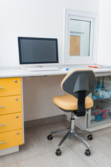 Yellow table with pc workplace at white bright medical office