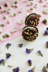 Composition of delicious chocolate macaroons and floral petals