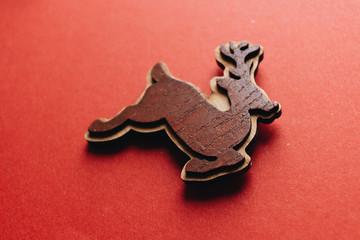 Hand made wooden deer on red background, Christmas bauble