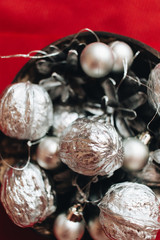 Christmas decoration with silver balls, baubles and pine cones on red background
