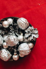 Obraz premium Christmas decoration with silver balls, baubles and pine cones on red background