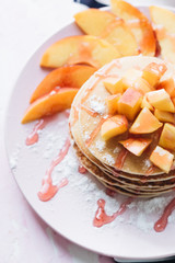 Stack of delicious homemade pancakes with sauce and sliced apple