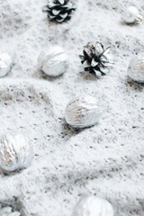 Flat lay of silver balls and pine cones on white background, Christmas pattern