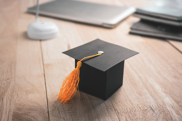 Construction paper craft graduation hat on wood desk