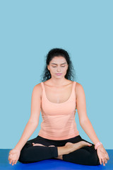Fototapeta premium Curly hair woman doing meditation in the studio