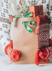 closeup of the hand of woman carrying a paper shopping bag full of gift boxes Christmas ornamented...