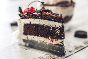 Delicious chocolate cake slice on white wooden table