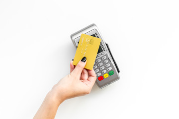 Pay by payment terminal. Paypass  technology. Woman's hand hold credit card, bring card to terminal  on white background top view copy space